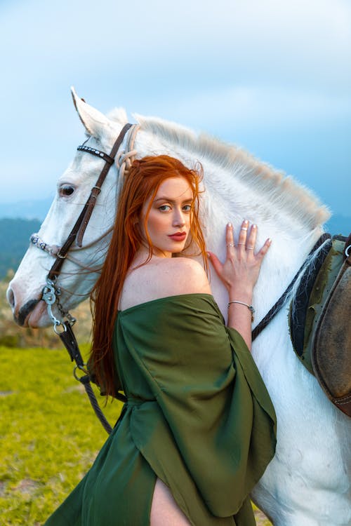 free-photo-of-redhead-woman-in-dress-posing-near-white-horse